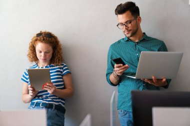Genç yönetici ofiste bilgisayar kullanırken tecrübeli meslektaşlarıyla konuşuyor. Meslektaşlar iş, mali ve pazarlama projelerini tartışırlar. Uzmanlar çeşitli başlangıç takımlarında çalışırlar.