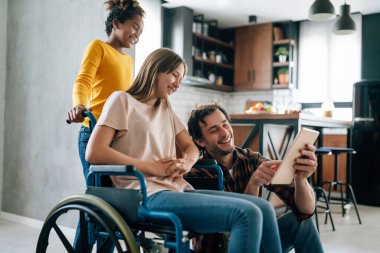 Tekerlekli sandalyede özürlü çocuklu, çok ırklı mutlu bir aile. Tek ebeveynlik