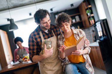Çok ırklı mutlu bir aile. Genç baba ve genç kız dijital tablet kullanıyor ve evde birlikte eğleniyorlar.