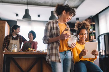 Çevrimiçi çalışma için dijital cihazlar kullanan mutlu çoklu etnik aile portresi. E-öğrenme, mutlu insanlar konsepti