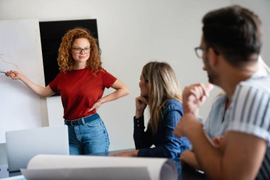 Gülümseyen çeşitli meslektaşlar toplantı odasında toplanmış mali istatistikleri tartışıyorlar. Mutlu çok ırklı iş arkadaşları ofis toplantılarında işbirliği yaparken eğleniyorlar. Takım çalışması konsepti.