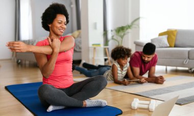 Mutlu Afro-Amerikan formda kadın çevrimiçi translarla çalışıyor. Ev egzersizi, spor salonu sağlıklı yaşam tarzı konsepti.
