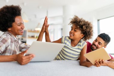 Teknolojik cihazlara takıntılı mutlu Afro-Amerikan genç ailesi dijital tablet, bilgisayar, akıllı telefonlar kullanıyor..