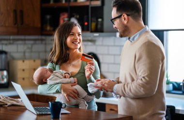 Evde dizüstü bilgisayarı olan, çocuklu neşeli bir aile. Aile mutluluk teknolojisi kavramı.