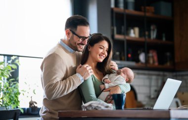 Evde dizüstü bilgisayarı olan, çocuklu neşeli bir aile. Aile mutluluk teknolojisi kavramı.