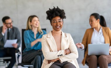 Mutlu orta yaşlı iş kadını yönetim kurulu başkanı çeşitli meslektaş şirketleriyle çalışarak proje yönetimi stratejisini tartışıyor.