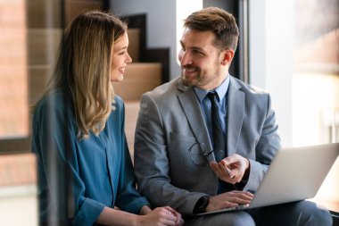 İş projesi ekibi şirket ofisindeki toplantı odasında birlikte çalışıyor.