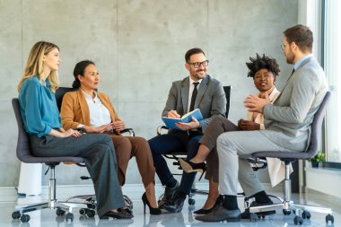 İş toplantısında ya da grup terapisinde tartışan insanlar. Meslektaşlarından oluşan bir ekip ofiste oturup tecrübeli koçun tavsiyelerini ve uzmanlığını paylaşıyor.