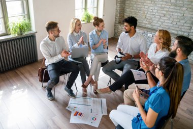 Çeşitli iş adamları tablolar ve grafiklerde mali raporu tartıştılar, iş ortakları ortak satış istatistiklerini analiz ederek grup toplantılarında anlaşma avantajları sundular