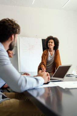 Mutlu, genç, Afro-Amerikan bayan liderleri, dost canlısı çeşitli meslektaşlarıyla toplantı yapıyor. Modern ofis odasında toplanıp proje fikirlerini tartışıyor ya da strateji geliştiriyor..