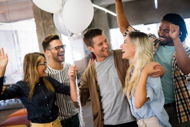 Mutlu, genç, başarılı, çoklu etnik çeşitlilikte iş dünyası takımı yeni açılan ofiste zaferi kutluyor..