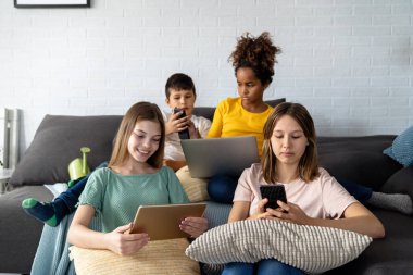 Dijital cihazlar kullanarak teknolojiyi elinde tutan çok ırklı gençlerden oluşan genç bir grup..