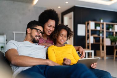 Mutlu siyah aile evde dijital cihazla eğleniyor. İnsanlar teknoloji aleti mutluluk kavramı.