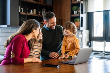 Neşeli bir aile, mutlu bir baba, mutlu bir anne ve sevimli bir oğul. Evde dizüstü bilgisayardan komik çizgi filmler izlerken gülüyorlar. Mutluluk, teknoloji, aile kavramı
