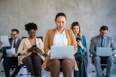 İş projesi ekibi şirket ofisindeki toplantı odasında birlikte çalışıyor.