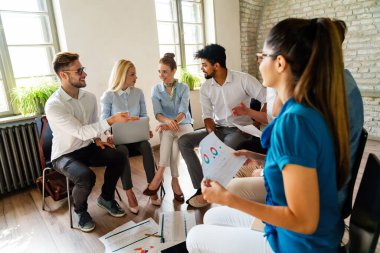 Çeşitli çalışanlar, beyin fırtınası sırasında ofiste toplanarak yeni projeleri için yeni fikirleri tartıştılar. Çok ırklı iş arkadaşları toplantı odasında toplanıp toplantıda fikir alışverişinde bulundular..