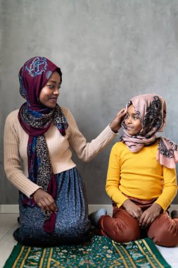 Müslüman anne ve kızı birlikte dua ediyorlar. Dini faaliyet kavramı