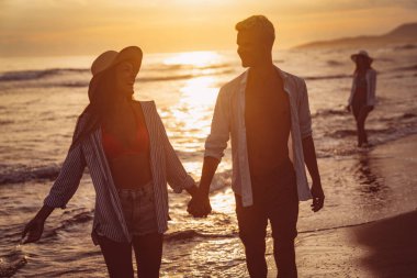 Genç çift denizde evlendikten sonra balayının tadını çıkarıyor. Mutlu sıradan bir çift el ele tutuşup sahilde yürüyor.