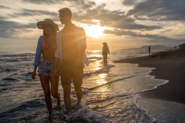 Genç çift denizde evlendikten sonra balayının tadını çıkarıyor. Mutlu sıradan bir çift el ele tutuşup sahilde yürüyor.