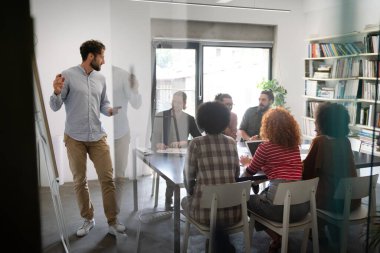 Ofisteki çeşitli çalışanlar yeni projeleri için yeni fikirleri tartışırken beyin fırtınası sırasında eğleniyorlar. Yönetim kurulundaki çok ırklı iş arkadaşları brifingde fikir alışverişinde bulundular..