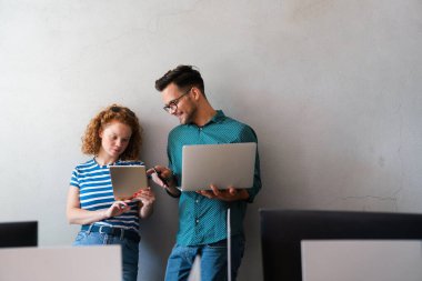 Dijital tablet kullanan mutlu iş arkadaşları, toplantı odasında dizüstü bilgisayar. İki genç iş adamı toplantı sırasında tartışıyorlar. Çeşitli girişimciler takım olarak çalışıyor..