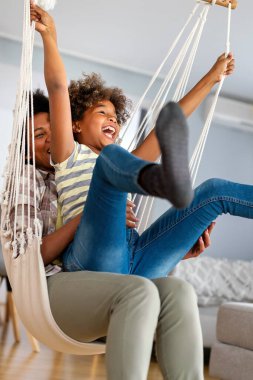 Birliktelik aile kavramı. Mutlu Afro-Amerikan anne ve kızı evde birlikte eğleniyor.