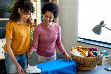 Mutlu siyah çocuk, annesine ev işlerinde ve ev işlerinde yardım ediyor. Mutlu aile kavramı.