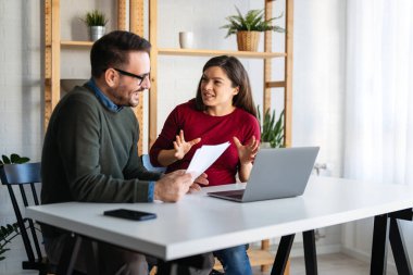 Ofiste yeni bir proje üzerinde çalışırken gülen iş adamları. Modern bir çalışma alanında çalışırken bilgisayar kullanan bir grup farklı iş adamı..