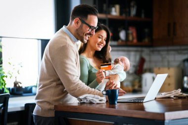 Evde internetten internetten alışveriş yapan çocuklu neşeli bir aile. Modern yaşam tarzı mutlu aile bebeği e-ticaret kavramını seviyor
