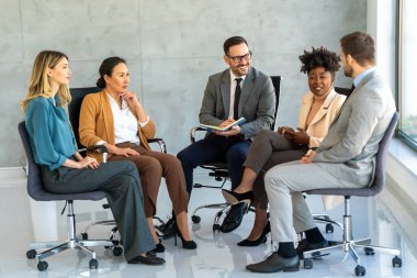 Etkili grup terapisi. Çok ırklı profesyonel insanlar bir araya gelip grup seansı yaparken birbirlerine bakıyorlar.