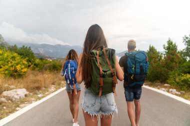 Çok ırklı en iyi arkadaşlar dışarıda eğleniyor. Yolculuktaki mutlu arkadaşlar yol kenarında iyi eğlenceler ve yaz tatilinin tadını çıkarın.