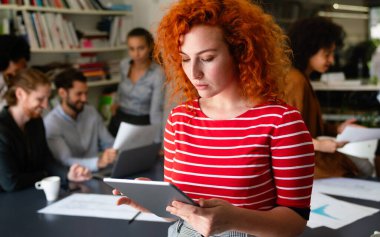 Başlangıç ofisinde duran mutlu genç iş kadını. İş başarısı kadın.