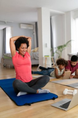 Spor yoga videoları. Evde spor yapma dersi online olarak canlı yayınlanıyor. Mutlu Afro-Amerikan kadın egzersizleri.