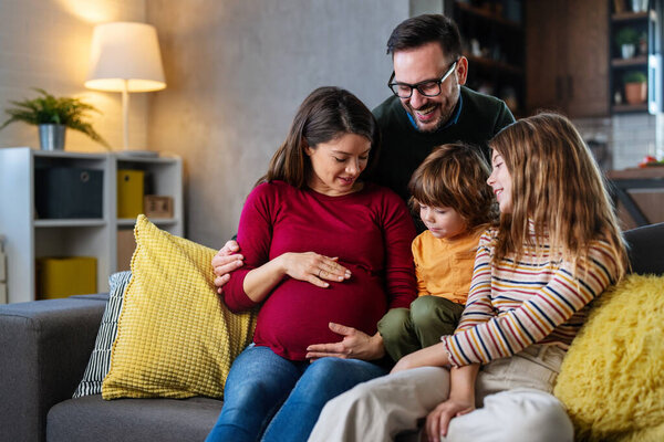 Happy family with pregnant mother and cute children have a fun at home and hug each other. People happiness family love concept