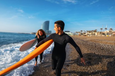 Okyanusta ellerinde sörf tahtası, spor, aktif yaşam tarzı, tatil, balayı olan birkaç güzel arkadaş.