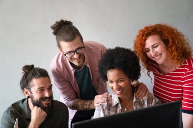 Mixed team of software engineers brainstorming ideas for new code library in front of computer screens compiling algorithms. Diverse app developers collaborating on group project in it agency office.