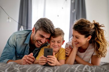 Mutlu teknoloji bağımlısı aile babası ve çocuk evde dizüstü bilgisayar dijital tableti kullanıyor, sosyal medyayı aşırı kullanan cihazlara takıntılı çocuk, internet bağımlılığı kavramı