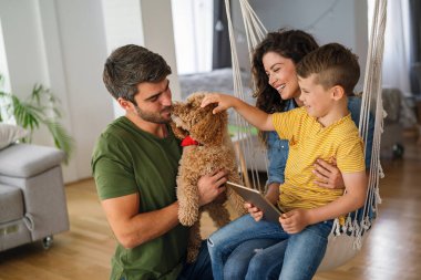 Mutlu aile, çocuklu ebeveynler başvuru ile eğleniyor, video karikatür izliyor ya da evde birlikte oyun oynuyorlar..