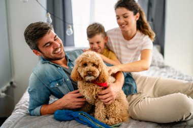 Mutlu bir aile oyunu, evde köpekle eğlenmek. Portre anne, baba ve çocuk oturma odasında kaliteli zaman, sevgi ve bakım için birlikte hafta sonu