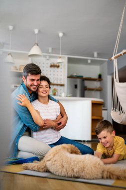 Mutlu bir aile oyunu, evde köpekle eğlenmek. Portre anne, baba ve çocuk oturma odasında kaliteli zaman, sevgi ve bakım için birlikte hafta sonu