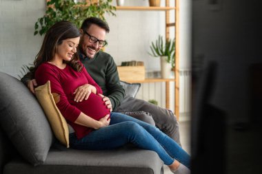 Aşk, şefkat, ilişki ve yeni aile kavramı. Aşık bir adam hamile karısına sarılır, birlikte bebeklerin gelmesini beklerler.