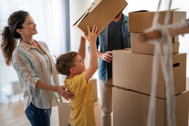Yeni ev, kutu ve çocuklu aileler, yeni ev kredisi ve gayrimenkul yatırımları. Ev sahibi, taşınma günü için heyecanlı aile, taşınma ve kiralama konsepti