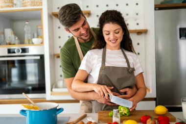 Genç mutlu çift evlerinde, mutfakta birlikte sağlıklı bir yemek hazırlıyorlar. Sağlıklı yaşam tarzı, kaliteli zaman, mutluluk, insan kavramı