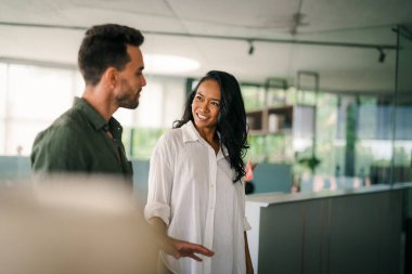 Neşeli çok ırklı meslektaşlar, ofis içi iş günlerinde başlangıç projesini tartışıyor ve gülümsüyor. Mutlu çeşitli başarılı iş arkadaşları yeni bir projede birlikte çalışıyorlar..
