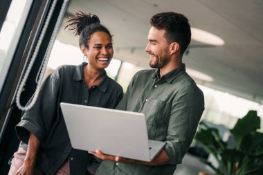 Ofisteki dijital cihazları kullanarak gülümseyen bir yönetici ekibi. Çeşitli profesyonel liderler yöneticiler ve çalışanlar takım çalışmasında çalışan dijital finans projesini tartışıyor.