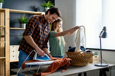 Mutlu bir baba ve kızı evde ev işleri yapıyor ve birlikte ütü yapıyor. İnsanların mutluluk kavramı.