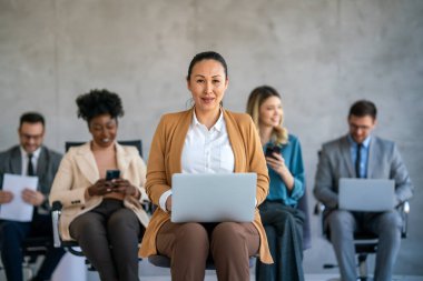 Tam konsantrasyon. Takım olarak çalışan ve kurumsal ofiste iletişim kuran bir grup genç iş adamı.