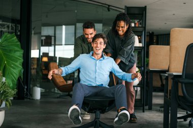 Coşkulu, çeşitli, etnik çeşitlilikte genç meslektaşlar ortak kurumsal başarıyı ya da hedef başarısını kutluyor, modern ofiste kaygısız parti zamanlarının tadını çıkarıyor.