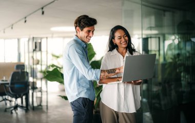 Neşeli çok ırklı meslektaşlar, ofis içi iş günlerinde başlangıç projesini tartışıyor ve gülümsüyor. Mutlu çeşitli başarılı iş arkadaşları yeni bir projede birlikte çalışıyorlar..