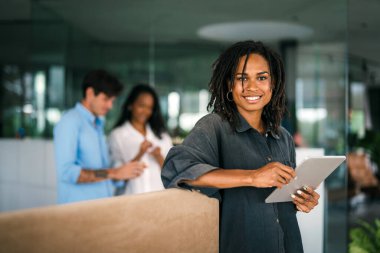 Gülümseyen Afro-Amerikan başarılı iş kadını, serbest çalışan, iş arkadaşı iş yerinde dijital cihaz kullanan kadın lider.
